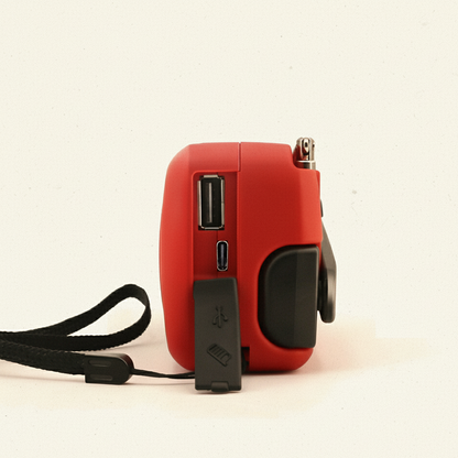 Close-up van de zijkant van de noodradio met het rubberen beschermklepje open, waardoor de USB-uitgang (powerbank) en de oplaadpoort zichtbaar zijn.
