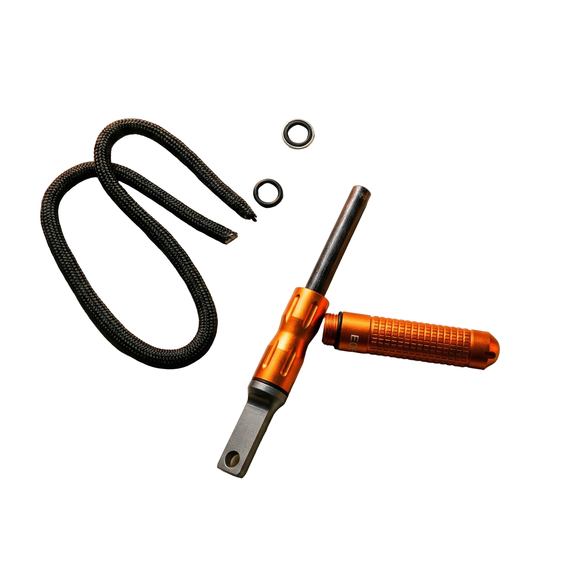 Complete inhoud verpakking oranje vuurstarter met draagkoord, ringen en de ferrocerium staaf